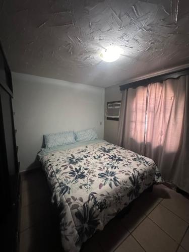 a bedroom with a bed with a floral bedspread at Condominio 1 in San Felipe