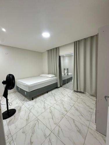a bedroom with a bed and a camera on the floor at Recanto Martins in Ipojuca