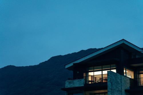 a building with the mountains in the background at Adagio Shihtiping in Fengbin