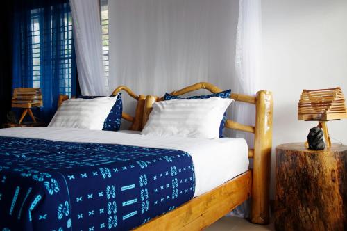 a bedroom with a bed with blue and white sheets at Spa Shallum in Kibuye