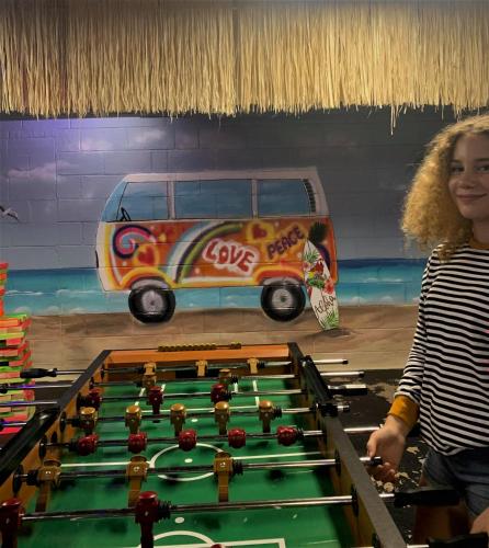 a woman standing next to a pool table with a van at Medley Manor in Creve Coeur