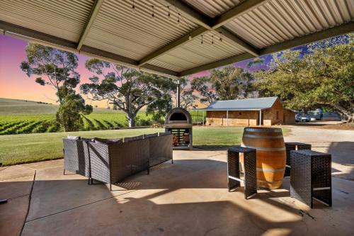 Un patio al aire libre con parrilla y chimenea. en Norm's Vineyard Retreat, en Lyndoch