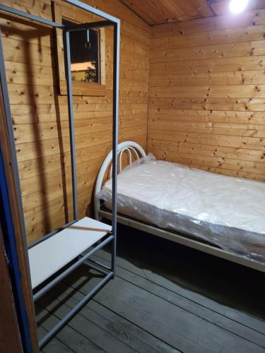 a small room with a bed in a wooden cabin at Blue Moon Cabin in Willemstad