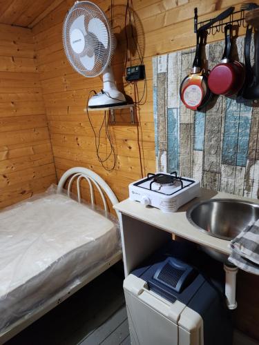 a kitchen with a sink and a bed in a room at Blue Moon Cabin in Willemstad