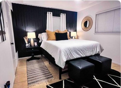 a bedroom with a bed and two lamps and a mirror at Pristine Full Sized Montrose Apartment Half Block to Menil Museum in Houston