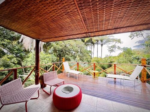 a porch with chairs and a table on a deck at Sunrise Paradise in Cayru