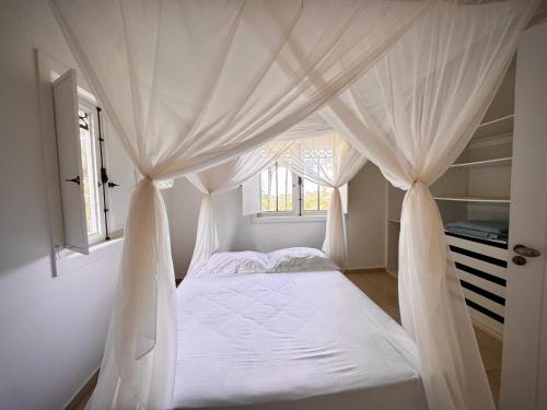 a bedroom with a canopy bed with a window at Sunrise Paradise in Cayru