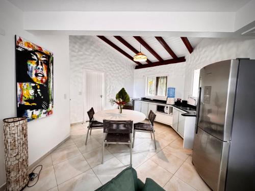 a kitchen with a table and chairs and a refrigerator at Sunrise Paradise in Cayru