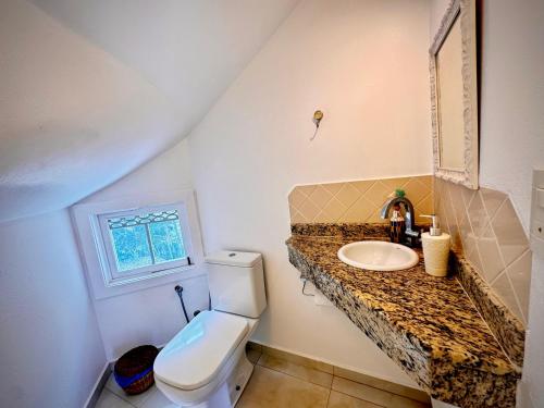 a bathroom with a toilet and a sink at Sunrise Paradise in Cayru