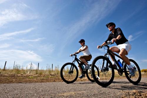 two men riding bikes on a gravel road at Pension Arabela in Harrachov