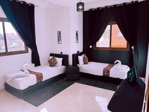 a bedroom with two beds and a window at Residence Chay - Luxury Appart in Ouarzazate