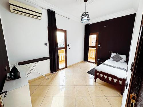 a bedroom with a bed and a room with windows at Residence Chay - Luxury Appart in Ouarzazate