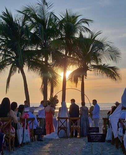 a group of people standing on the beach watching the sunset at Oceanfront Casa Rhino in Paso Hondo