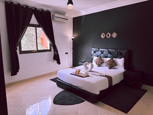 a bedroom with a large bed with a black wall at Residence Chay - Luxury Appart in Ouarzazate