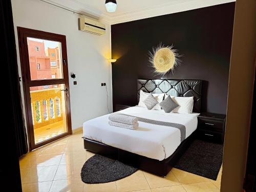 a bedroom with a large bed with a black wall at Residence Chay - Luxury Appart in Ouarzazate