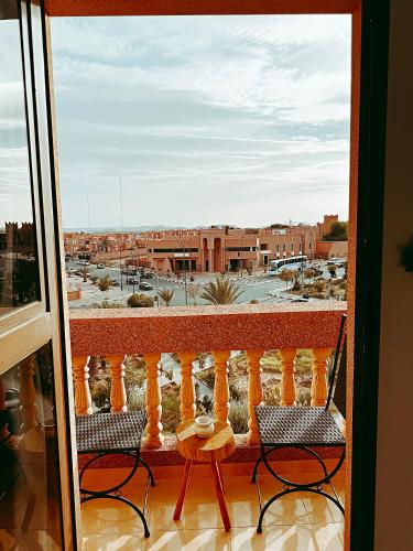 a balcony with two chairs and a view of a parking lot at Residence Chay - Luxury Appart in Ouarzazate