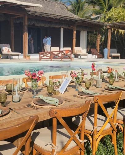 a wooden table next to a swimming pool at Oceanfront Casa Rhino in Paso Hondo