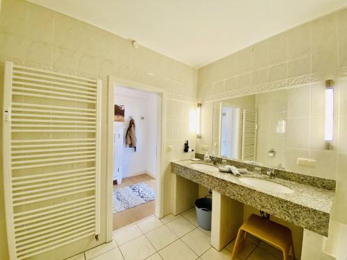 ein Badezimmer mit Waschbecken und großem Spiegel in der Unterkunft Ferienwohnung Binzer Seeblick Haus Jahreszeiten Binz in Binz