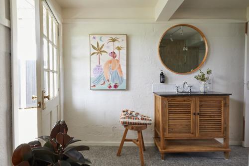 a bathroom with a mirror and a wooden dresser at Coach Road Beach House in Indented Head