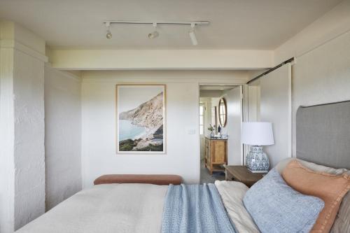 a bedroom with a bed and a painting on the wall at Coach Road Beach House in Indented Head