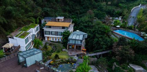 张家界Zhangjiajie Rock language art hotel-Free pick up service的享有房子和游泳池的空中景致