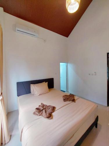 a bedroom with a bed with two bows on it at Yustien Homestay Jogja 3 Bedroom - Private Villa in Bantul