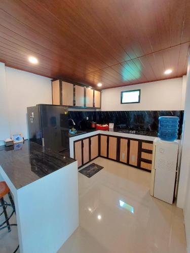 a kitchen with a counter and a refrigerator at Yustien Homestay Jogja 3 Bedroom - Private Villa in Bantul
