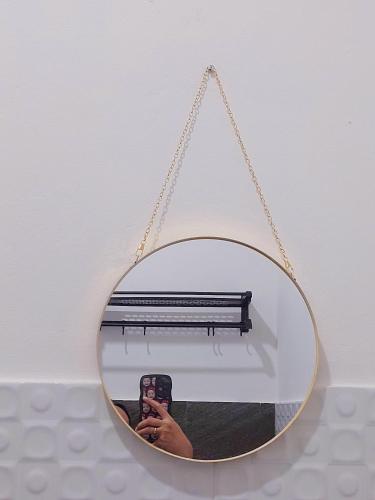 a person taking a picture of a bench in a mirror at Yustien Homestay Jogja 3 Bedroom - Private Villa in Bantul