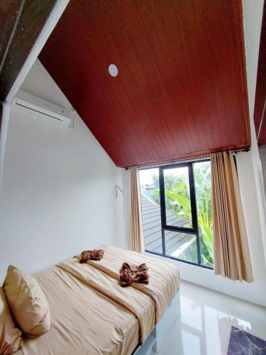 a bedroom with a bed and a large window at Yustien Homestay Jogja 3 Bedroom - Private Villa in Bantul
