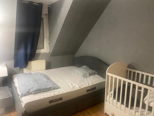 - une petite chambre avec un lit bébé et un plafond dans l'établissement Appartement non loin de Disney, à Bussy-Saint-Georges