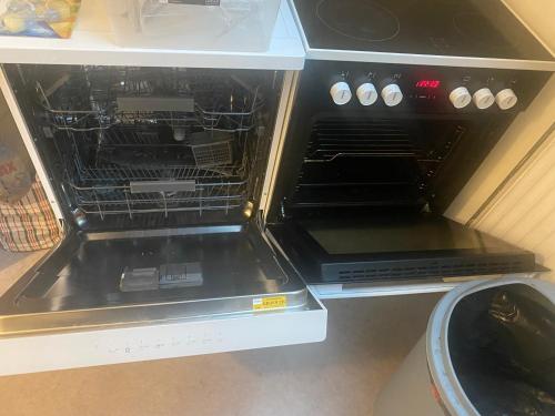 un four avec sa porte ouverte dans une cuisine dans l'établissement Appartement non loin de Disney, à Bussy-Saint-Georges