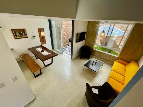 a living room with a yellow couch and a table at The blue house in La Cañada