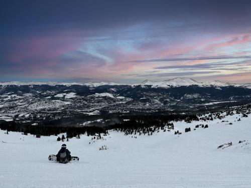 a snowboarder sitting on top of a snow covered mountain at Rockridge 41 by Summit County Mountain Retreats in Breckenridge