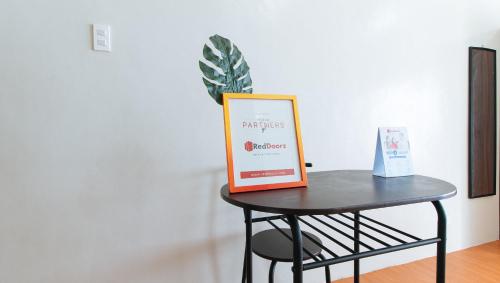 a table with a framed sign on top of it at RedDoorz @ Mary Land Transient Alaminos Pangasinan in Alaminos