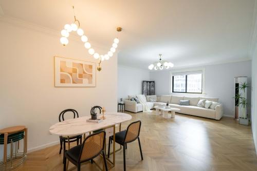 a living room with a table and chairs and a couch at Nanjing West Road elevator two-bedroom, three-bed apartment close to the subway in Shanghai