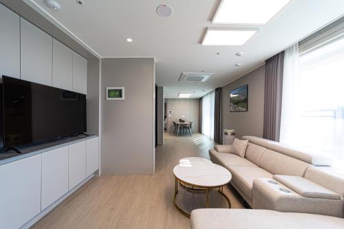 a living room with a couch and a flat screen tv at Bella Stay in Chuncheon