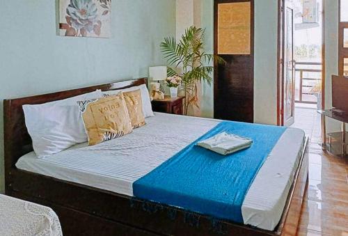 a bedroom with a bed with a blue blanket on it at RedDoorz @ Mary Land Transient Alaminos Pangasinan in Alaminos