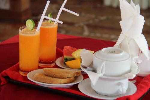 a red table with plates of food and drinks at Al-Minar Hotel in Zanzibar City