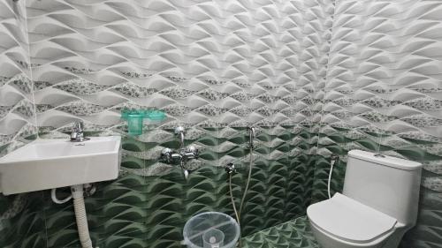 a bathroom with a toilet and a sink at MetroResidency com in Chennai
