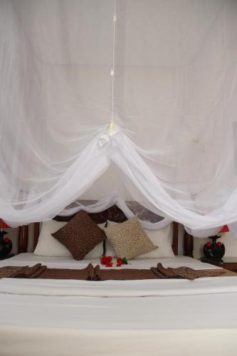 a white tent with pillows on a bed at Al-Minar Hotel in Zanzibar City