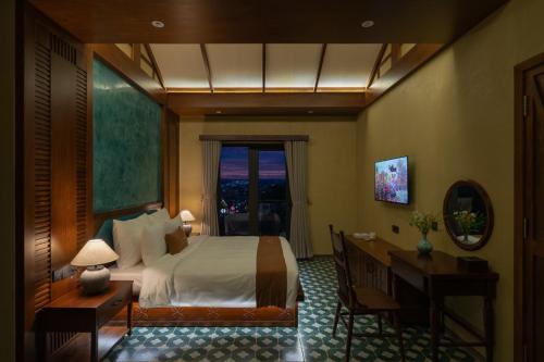 a hotel room with a bed and a window at The Mist Boutique DaLat Hotel in Da Lat