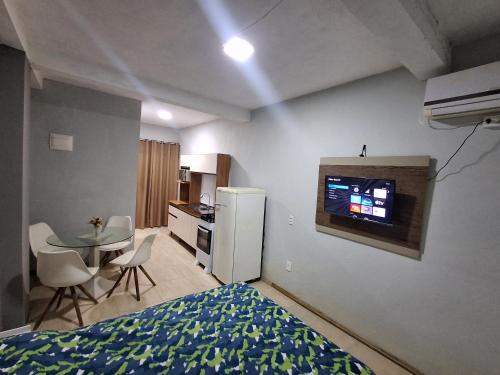 ボンビーニャスにあるResidencial Zimbros 2のベッドとテーブルとキッチンのある寝室