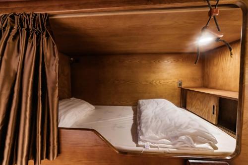 a small bed in a small room with a light at Xuân Home in Trai Mat