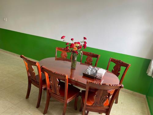 un tavolo da pranzo con un vaso di fiori sopra di Villa đà lạt - happy family house a Da Lat