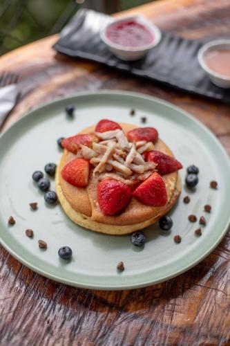 un pancake con fragole e mirtilli su un piatto di EcoHotel Casa Maria Parda a Cocorná
