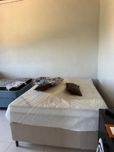 a bed with two pillows on it in a room at Casa branca in Marataizes