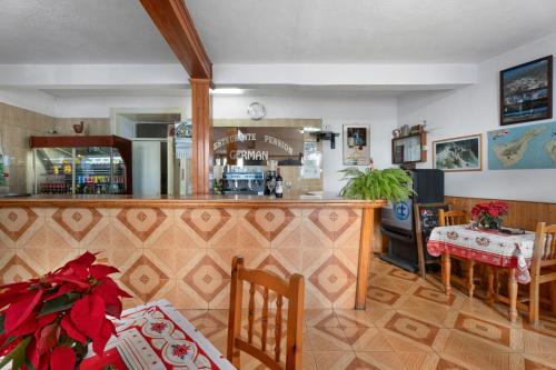 a bar in a restaurant with a table and chairs at Hotel Germán in Vilaflor