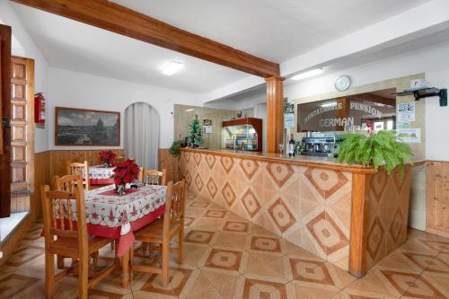 a dining room with a table and a kitchen at Hotel Germán in Vilaflor