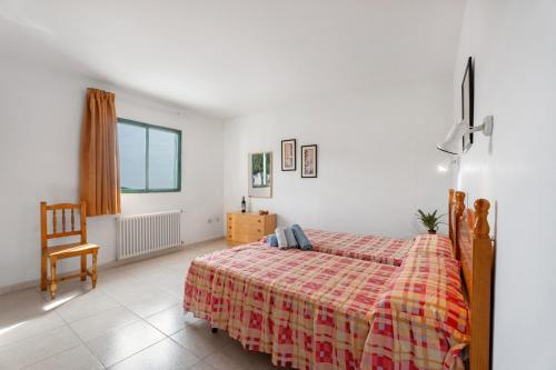a bedroom with a bed and a chair at Hotel Germán in Vilaflor