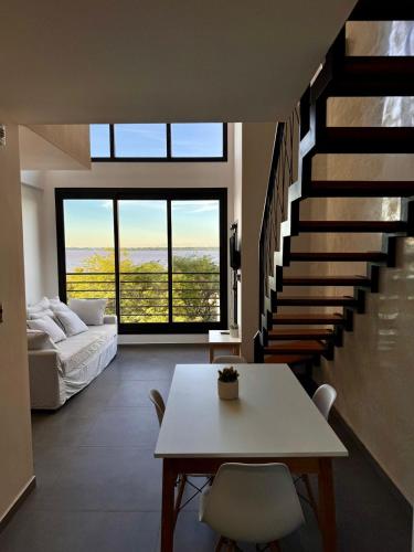 a living room with a table and a staircase at DPTO 401 Edif Loftier in Posadas